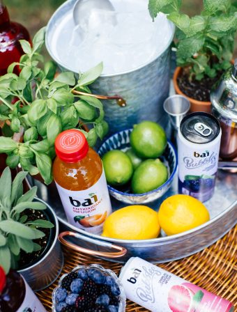 A bucket of ice with limes, lemons, berries, Bai Costa Rica Clementine, and Bai Bubbles Bogota Blackberry Lime and Bai Bubbles Gimbi Pink Grapefruit