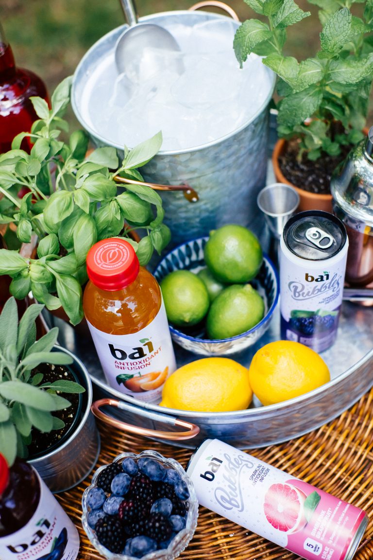 A bucket of ice with limes, lemons, berries, Bai Costa Rica Clementine, and Bai Bubbles Bogota Blackberry Lime and Bai Bubbles Gimbi Pink Grapefruit