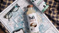 Bai Molokai Coconut and Bai Supertea on a map with glasses and a phone