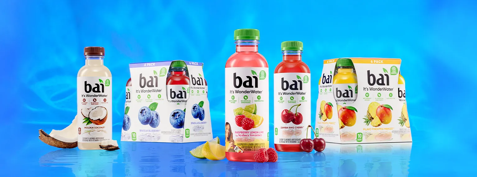 Bai Bottles and some Bai 6 packs next to fruit showcasing their respective flavors